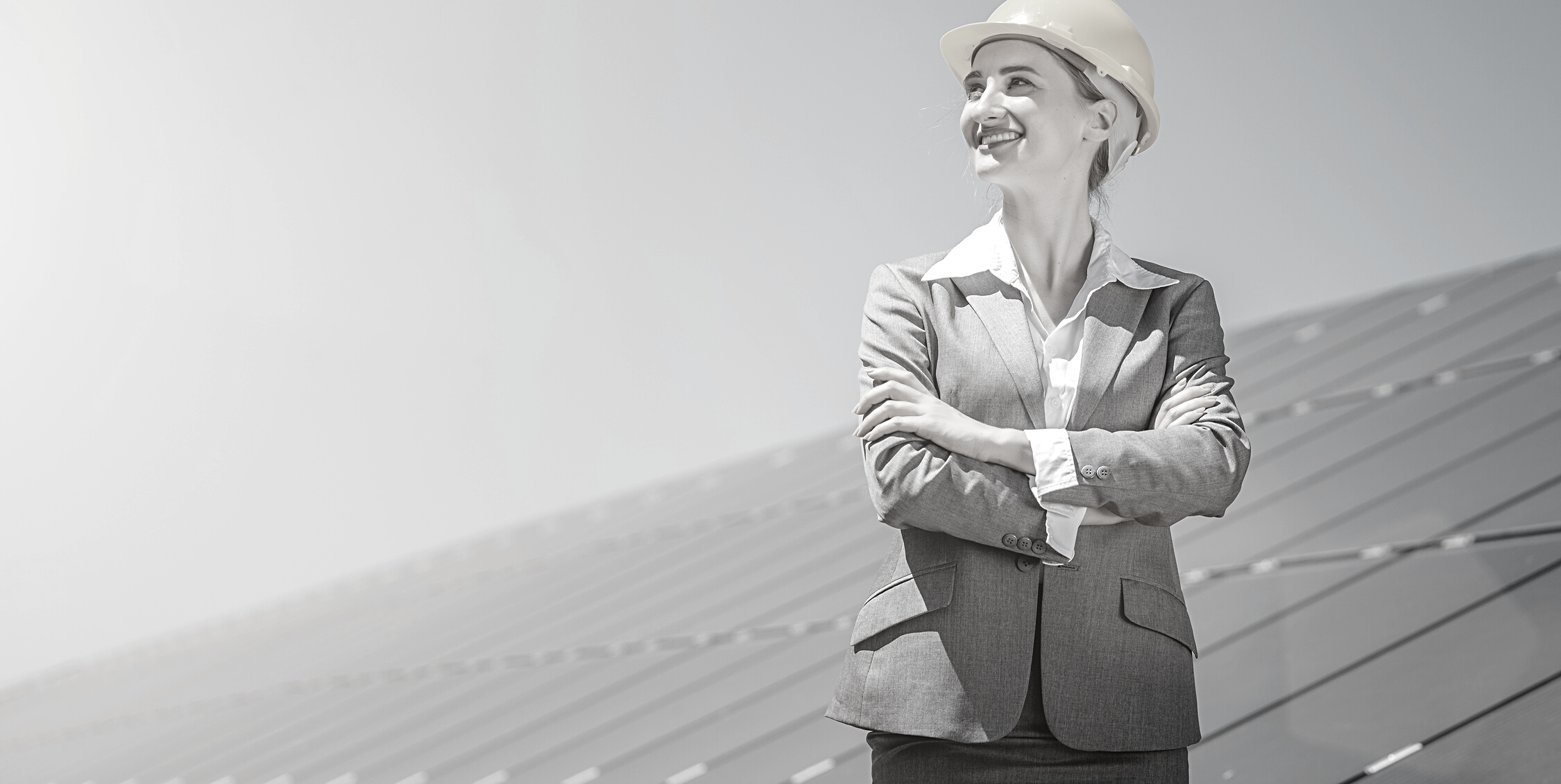 Woman Investor in Clean Energy Standing in Front of Solar Panels